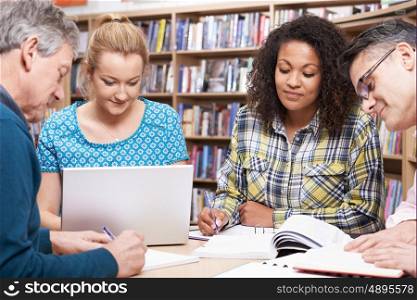 Group Of Mature Students Studying In Library