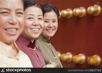Group of mature women in traditional clothes standing next to the traditional Chinese door