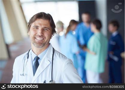 group of medical staff at hospital, handsome doctor in front of team, people group standing together in background