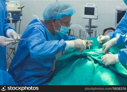 Group of medical team urgently doing surgical operation and helping patient in theater at hospital