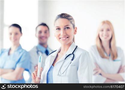 group of medics with female doctor holding syringe with injection. female doctor holding syringe with injection