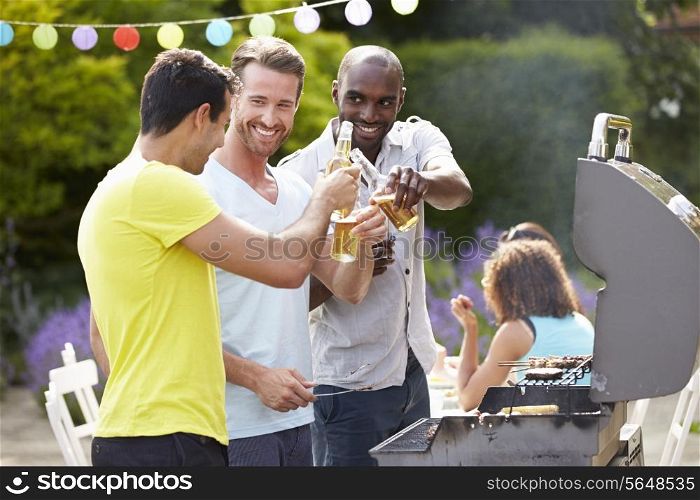 Group Of Men Cooking On Barbeque At Home
