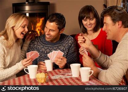Group Of Middle Aged Couples Playing Cards Together