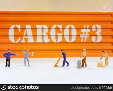 Group of miniature people workers figure with cargo container at warehoue, industrial and logistic concept