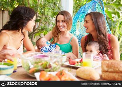 Group Of Mothers With Babies Enjoying Outdoor Meal At Home