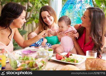 Group Of Mothers With Babies Enjoying Outdoor Meal At Home