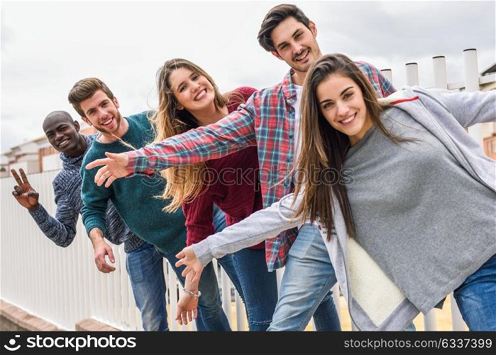 Group of multi-ethnic young people having fun together outdoors in urban background