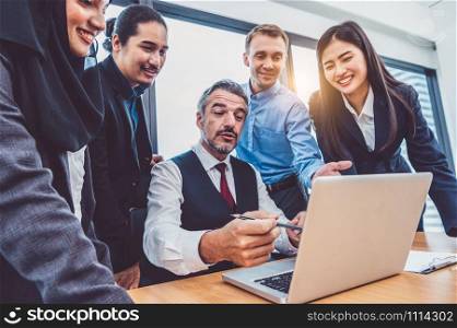 Group of multiethnic business people trainning by executive senior boss in modern office with laptop computer. Startup team meeting and brainstorming, Working people having conference workshop concept