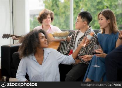 Group of multiethnic friends having fun at party by playing guitar and singing together at home.
