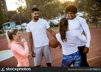 Group of multiethnic young people  playing basketball on court