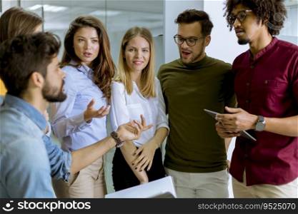 Group of multiracial businesspeople standing and disscusing in modern office