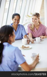 Group Of Nurses Chatting In Modern Hospital Canteen