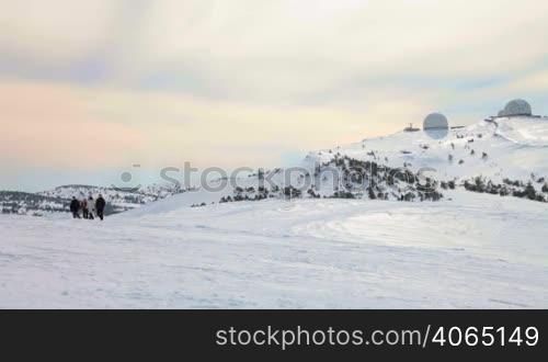 group of people are walking on snow-covered summit of Mount Ai-Petri, Crimea