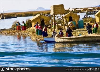 Group of people at a lakeside, Lake Titicaca, Uros Floating Islands, Puno, Peru