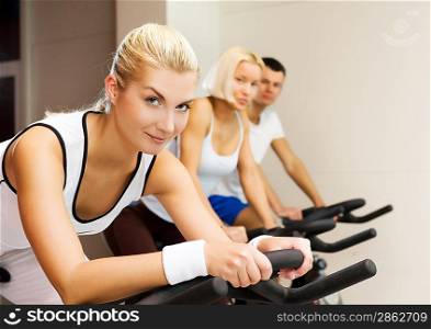 Group of people doing exercise on a bike in a gym