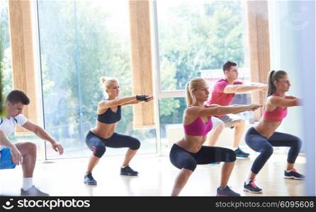 Group of people exercising at the gym and stretching