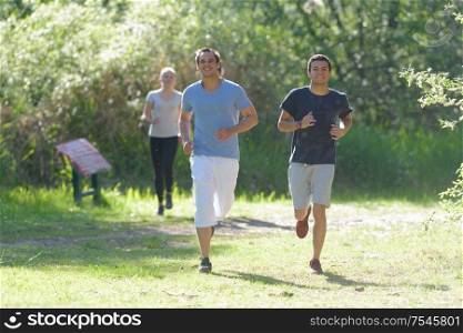 group of people exercising jogging through park together