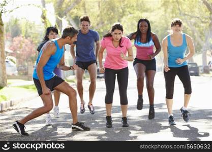 Group Of People Exercising Street With Personal Trainer