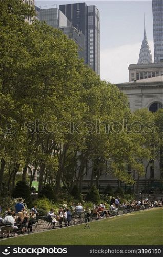 Group of people in a park with skyscrapers in the background, Chrysler Building, Manhattan, New York City, New York State, USA
