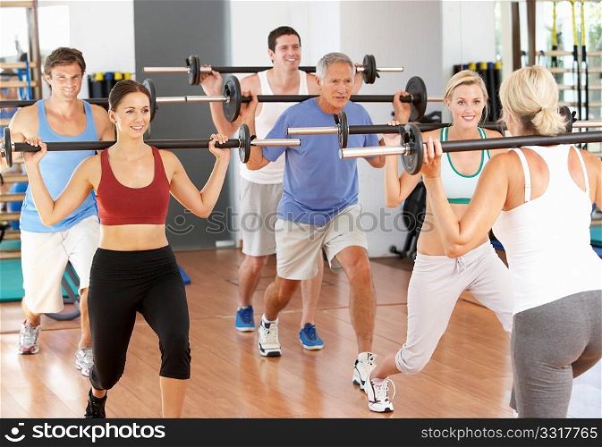 Group Of People Lifting Weights In Gym