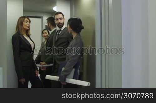 Group of people on elevator. Business women and man talking, manager with secretary, white collar workers, colleagues, co-workers, businesspeople on lift in office building. 4 of 15