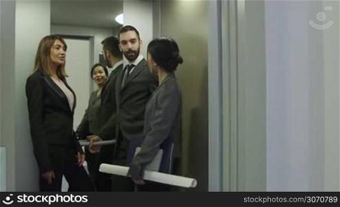 Group of people on elevator. Business women and man talking, manager with secretary, white collar workers, colleagues, co-workers, businesspeople on lift in office building. 4 of 15