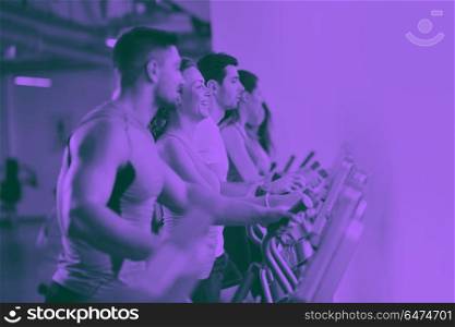 Group of people running on treadmills. group of young people running on treadmills in modern sport gym duo tone
