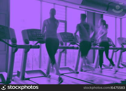 Group of people running on treadmills. group of young people running on treadmills in modern sport gym duo tone