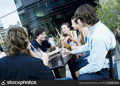 Group of people sitting together at a sidewalk cafe