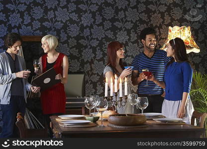 Group of people smiling, standing by dining table