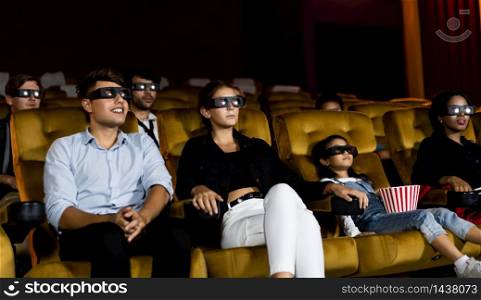 Group of people watch movie with 3D glasses in cinema theater with interest looking at the screen, exciting and enjoy