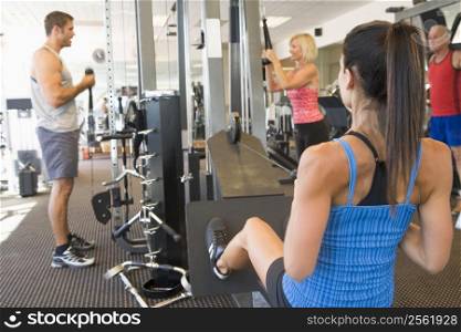Group Of People Weight Training At Gym