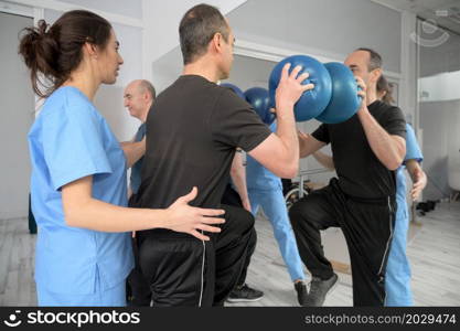 Group of People with disability exercising at rehabilitation clinic. High quality photo. Group of People with disability exercising at rehabilitation clinic.