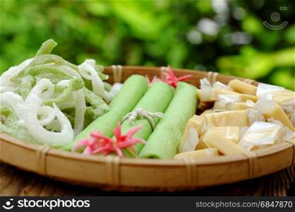 Group of product from coconut with candy, milk rice paper, coconut oil, dark soy sauce, jam or coconut water, are popular Vietnam food, group of snacks and drink on green background