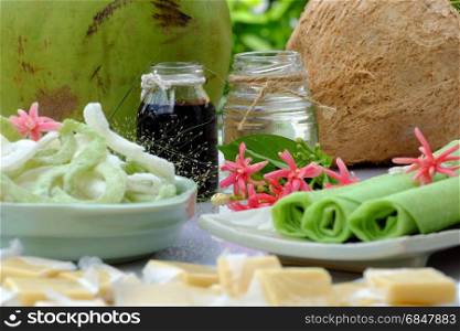 Group of product from coconut with candy, milk rice paper, coconut oil, dark soy sauce, jam or coconut water, are popular Vietnam food, group of snacks and drink on green background
