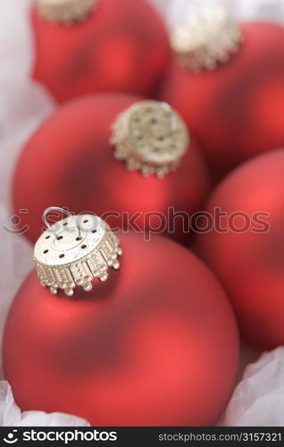 Group Of Red Christmas Tree Decorations Wrapped In Tissue Paper