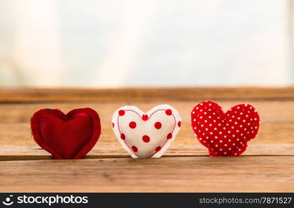 Group of Red hearts handmade craft from silk and cotton cloth put in hole of wood surface with white curtain on background, valentine&rsquo;s day and love symbol