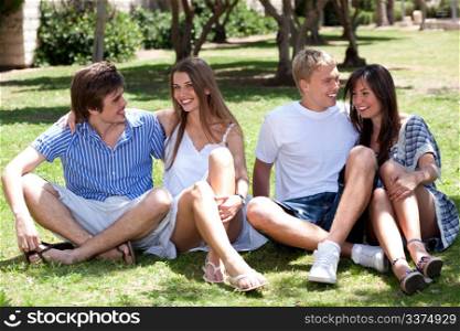 group of Romantic couples sitting on the green grass in the park