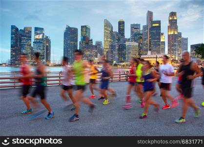 Group of runners on Singapore quayside at twilight