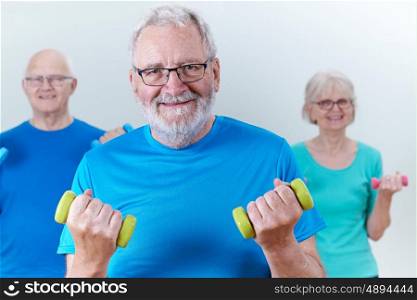 Group Of Seniors In Fitness Class Using Weights