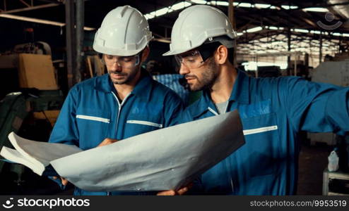 Group of skillful factory workers using machine equipment in workshop . Industry and engineering people technology concept .