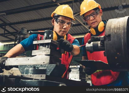 Group of skillful factory workers using machine equipment in workshop . Industry and engineering people technology concept .. Group of skillful factory workers using machine equipment in workshop