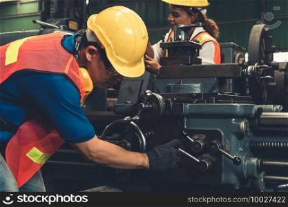 Group of skillful workers using machine equipment in factory workshop . Industry and engineering people technology concept .. Group of skillful workers using machine equipment in factory workshop
