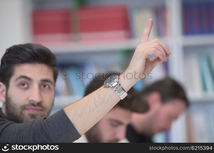 group of smart students raise hands up in school classroom on class