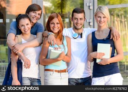 Group of smiling students standing front of college campus summer