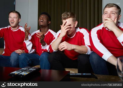 Group Of Sports Fans Watching Game On TV At Home