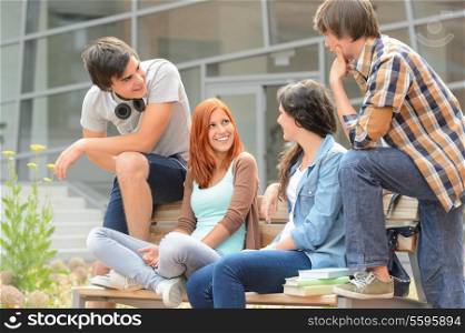 Group of student friends sitting bench outside college hanging out