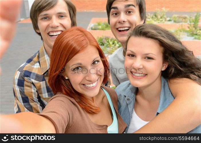 Group of student teenage friends taking selfie laughing at camera
