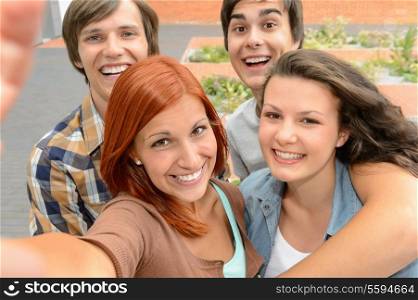 Group of student teenage friends taking selfie laughing at camera