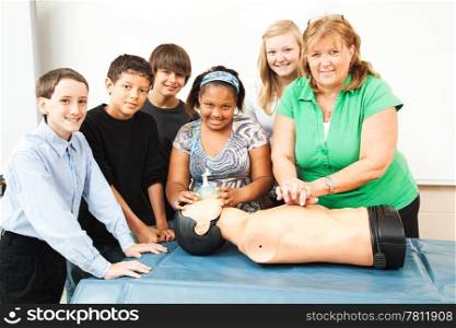 Group of students and their teacher, learning CPR in school.